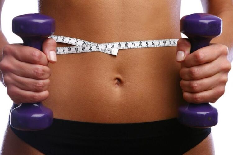 Fitness dumbbells in the hands of a suitable girl